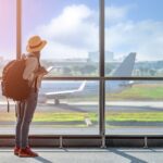 woman at airport waiting for flight after securing travel insurance