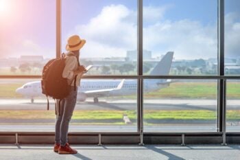 woman at airport waiting for flight after securing travel insurance