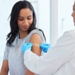 a woman getting a vaccination before traveling abroad