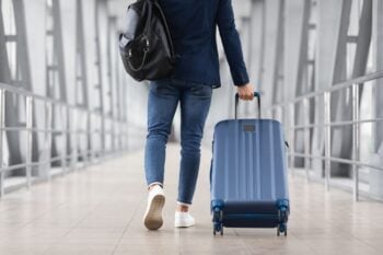 a man pulling a suitcase in an airport having read some top tips on how to buy travel insurance