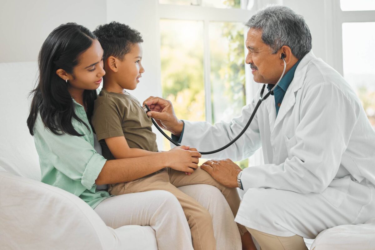 a doctor performing a medical checkup of a little boy, indicating the importance of finding a doctor abroad