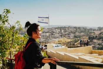 a foreign woman overlooking an old city in Israel, having secured insurance