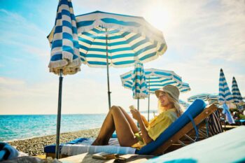 a young woman relaxing at a luxury hotel on holiday in the Côte d'Azur, France, having secured holiday insurance for her trip