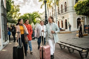 A group of senior women travelers with suitcases exploring a foreign destination, having bought short-term medical insurance for international travel