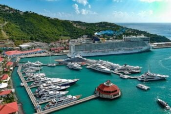 Large cruise ship docked in St. Thomas Harbor with clear blue skies and turquoise waters, promoting the importance of cruise insurance for a worry-free voyage