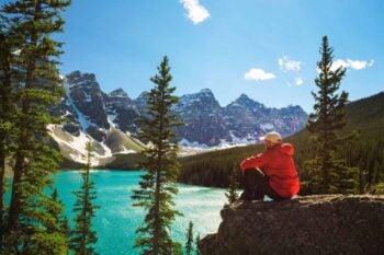 a hiker enjoying the view of Moraine Lake in Banff National Park, Canada, after securing travel insurance for Canada