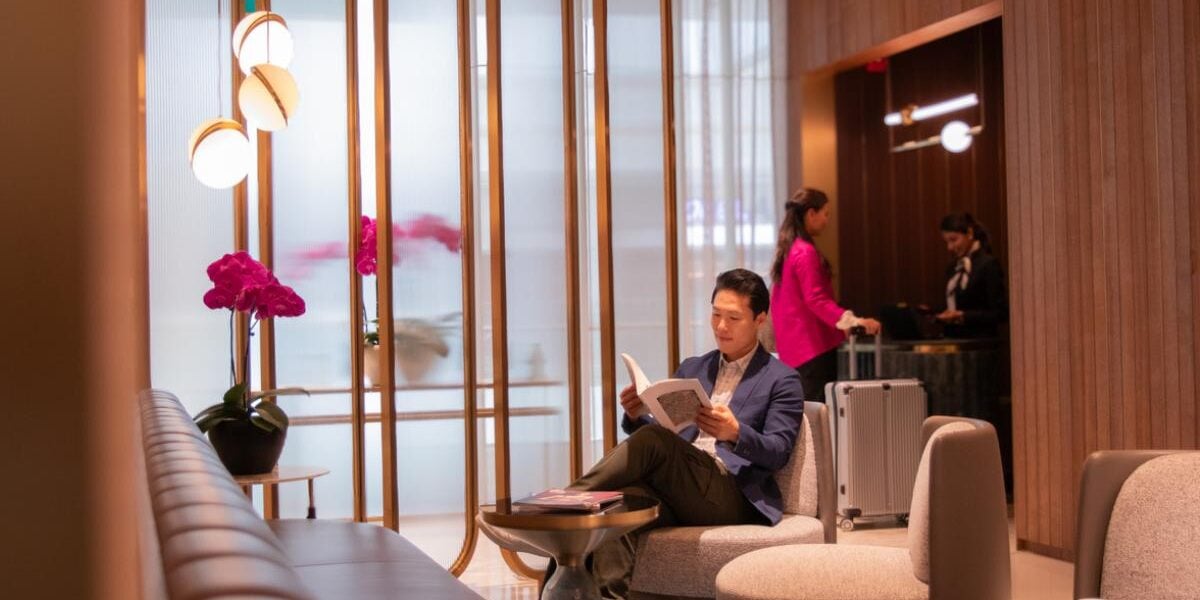 an Asian man reading and relaxing in a quiet airport lounge in a VIP lounge at Singapore Changi Airport