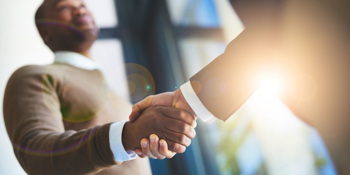 two businessmen shaking hands, representing a strong professional relationship and the importance of securing insurance for employees