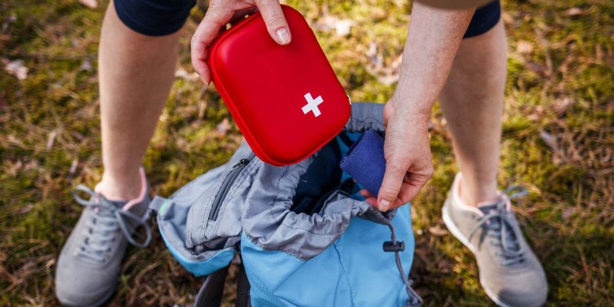 A hiker taking out a first aid kit from their backpack