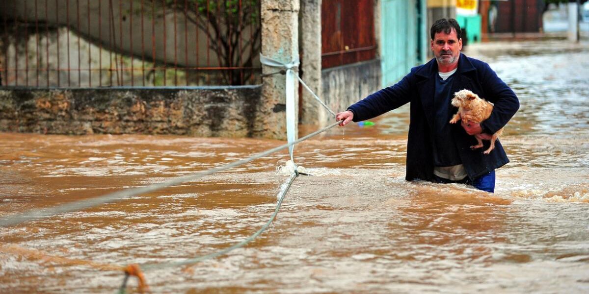 A wan rescuing a dog during a heavy flood in Brazil