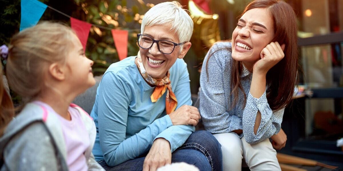 an older woman traveler visiting her daughter and granddaughter, safe in the knowledge that she has travel insurance for seniors