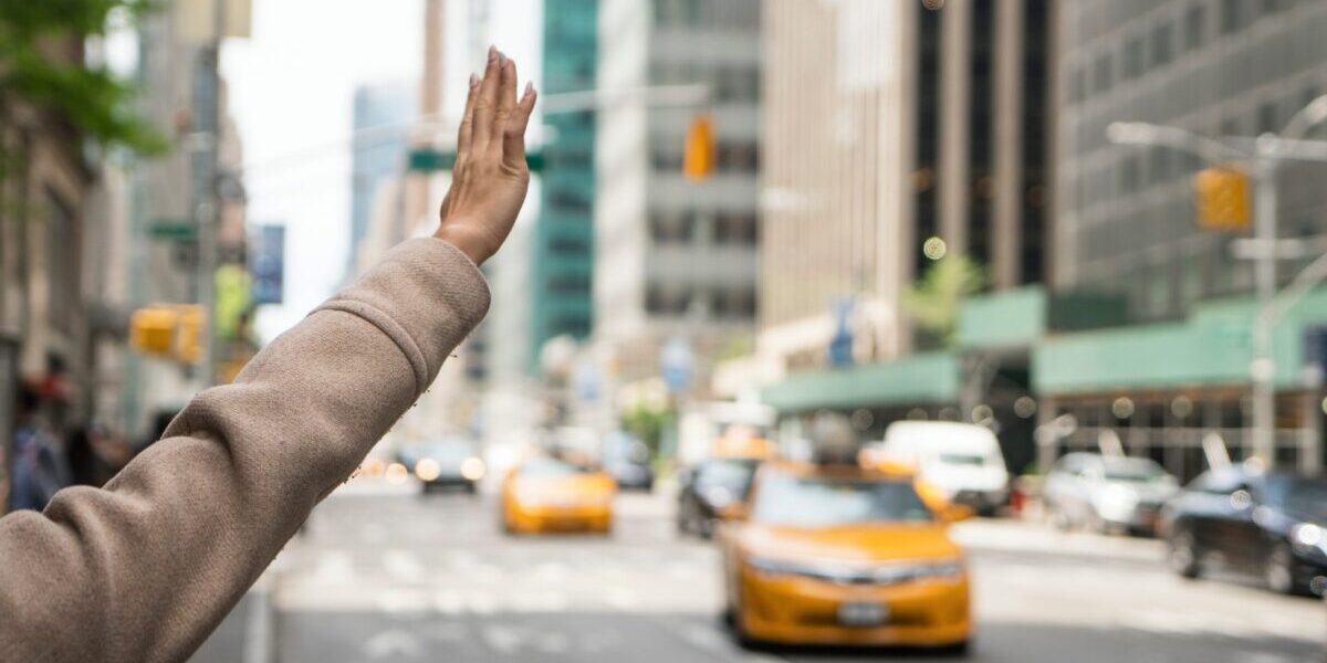 a young woman hailing a licensed taxi in New York in an attempt to reduce the risk of falling victim to terrorism