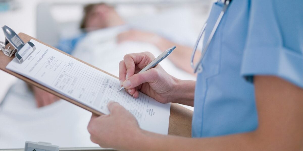 a doctor filling in paperwork for a patient in a country with a reciprocal healthcare agreement