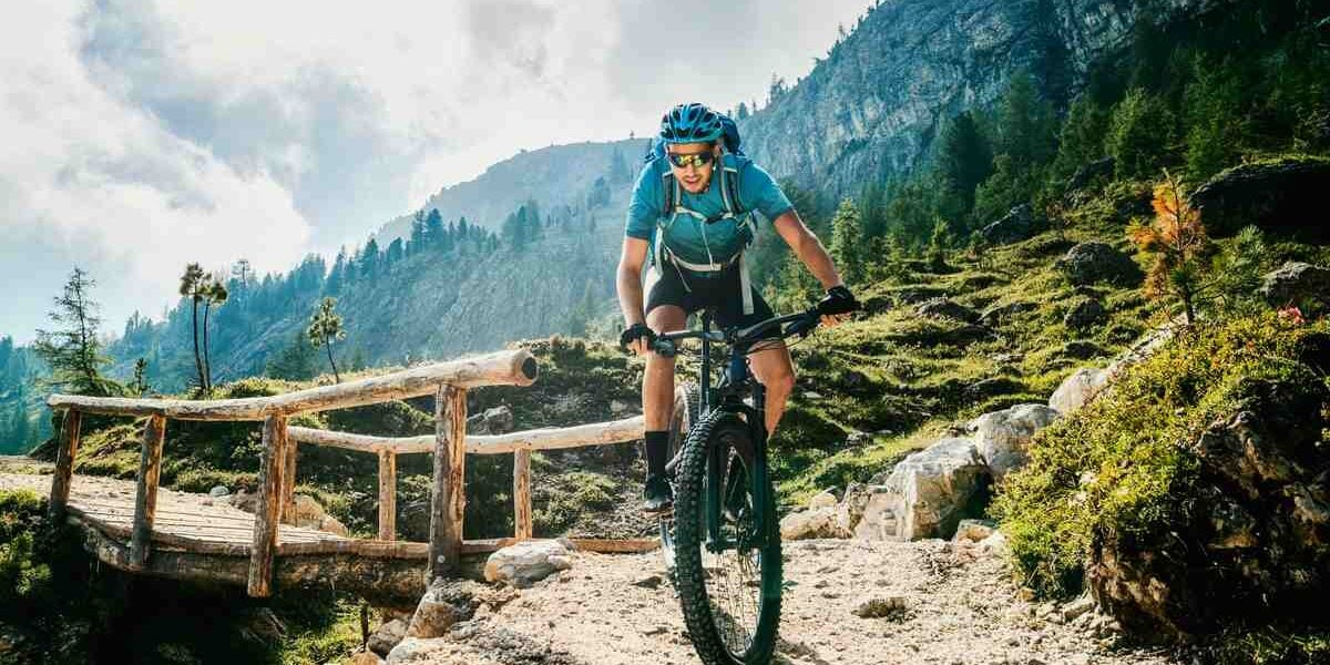 A mountain biker riding through the rugged terrain of the Dolomites in Italy during his adventure travel experience