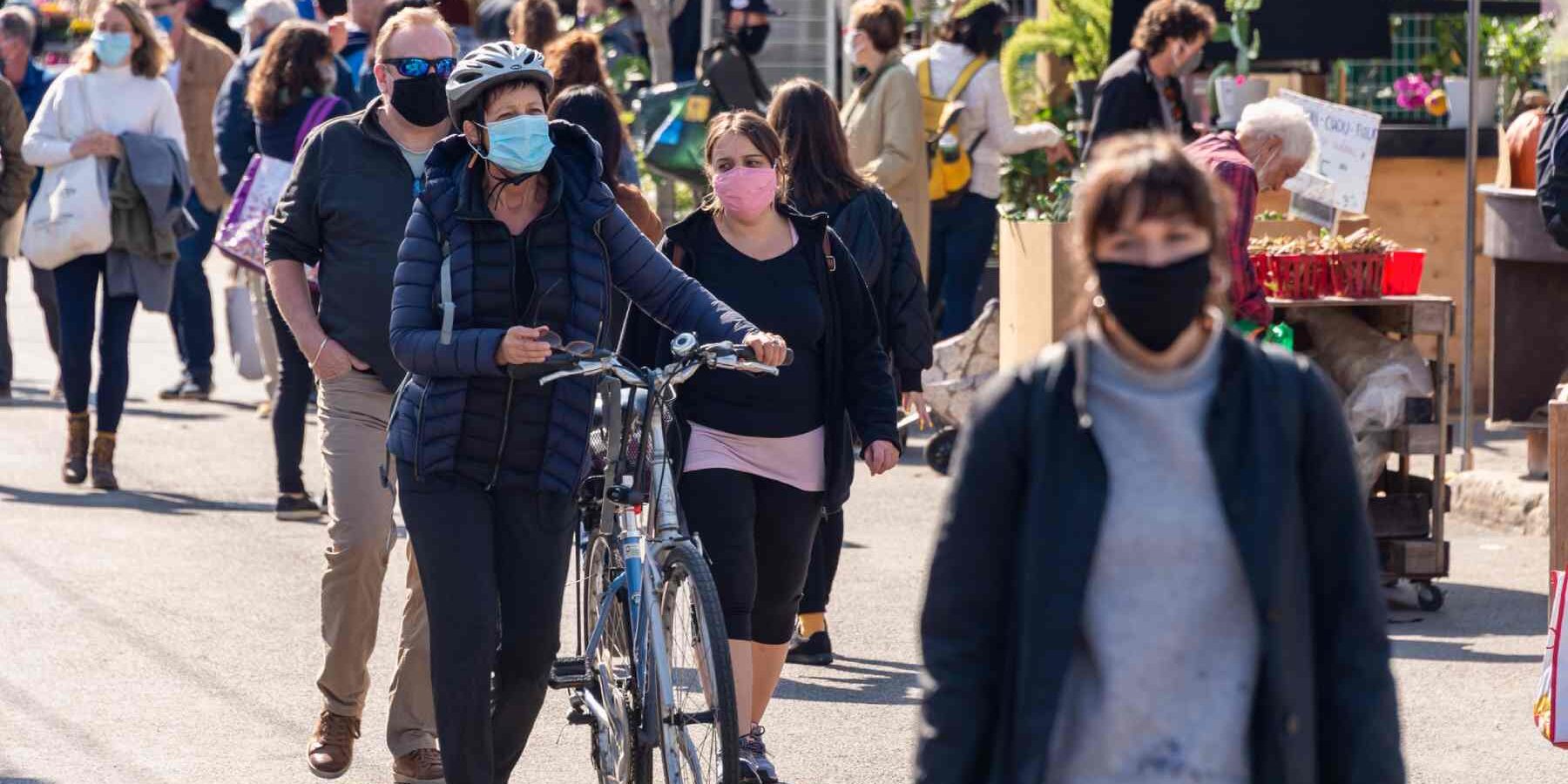 people wearing Coronavirus face masks at Jean Talon Market in Montreal, reflecting the strain the pandemic placed on the Canadian healthcare system