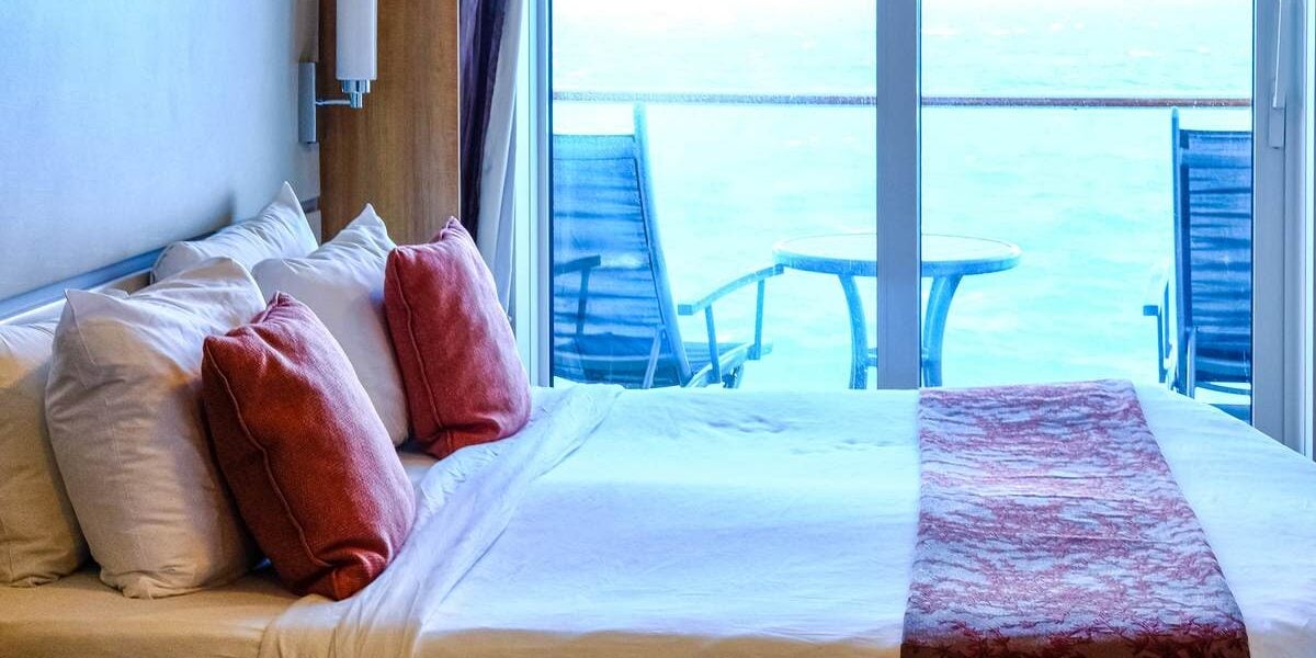 a bedroom on a cruise liner, with a window showing the horizon; one of the best cruise tips to avoid seasickness