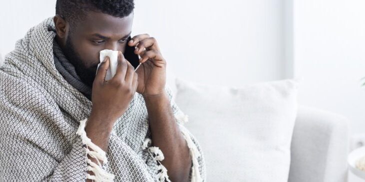 Sick black man calling on phone to doctor