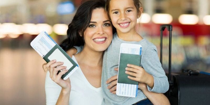 woman and child holding passports and plane tickets, safe in the knowledge that they have travel insurance