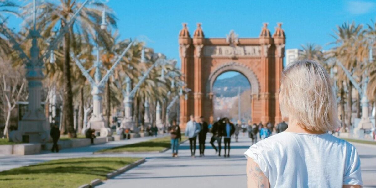 a woman standing in front of a landmark archway in Spain